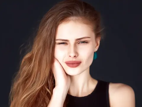 AuraDent Estetik Klinik – Lefkoşa’da diş sıkma (bruksizm) nedeniyle çene ağrısı ve TME bozukluğu yaşayan İtalyan kadın. Botox, gece plağı ve diş taşı temizliği gibi bruksizm tedavileri ile çene sağlığında rahatlama